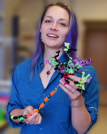 Portrait of Sami Friedrich holding a model neuron